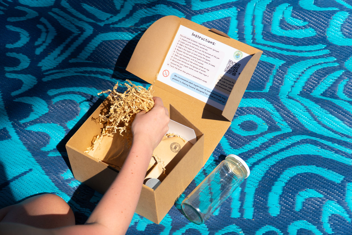 A girl opens the box of her EnviroMentoring Wiggly Worms DIY Kit.