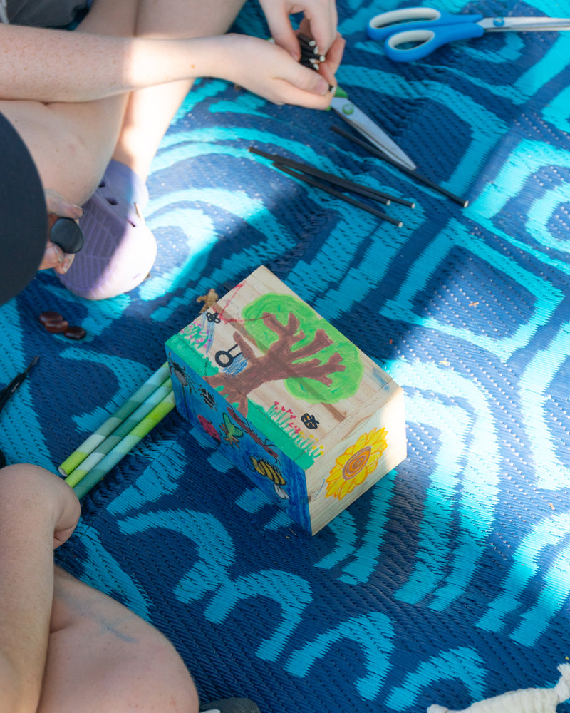 Top view of boys decorating the EnviroMentoring DIY Bug Hotel Kit with eco-friendly rock crayons.