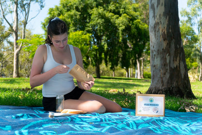 A girl scoops out sand to layer into her EnviroMentoring Wiggly Worms DIY Kit wormery.